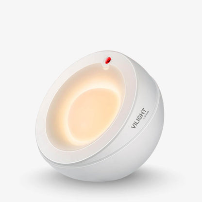Product photography of a VILIGHT by O Rons white spherical lamp with a warm yellow glow emanating from its inner concave design and a small red indicator light